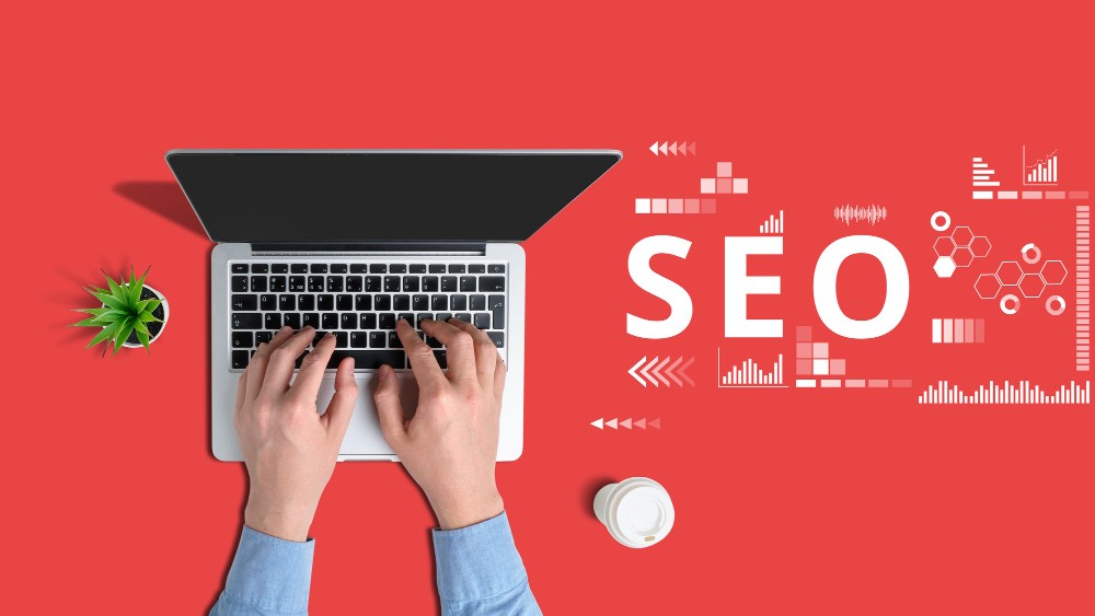 אדם שעובד על מחשב נייד עם האותיות "SEO" מוצגות בצורה בולטת, מוקף בסמלים וגרפיקות שונות.